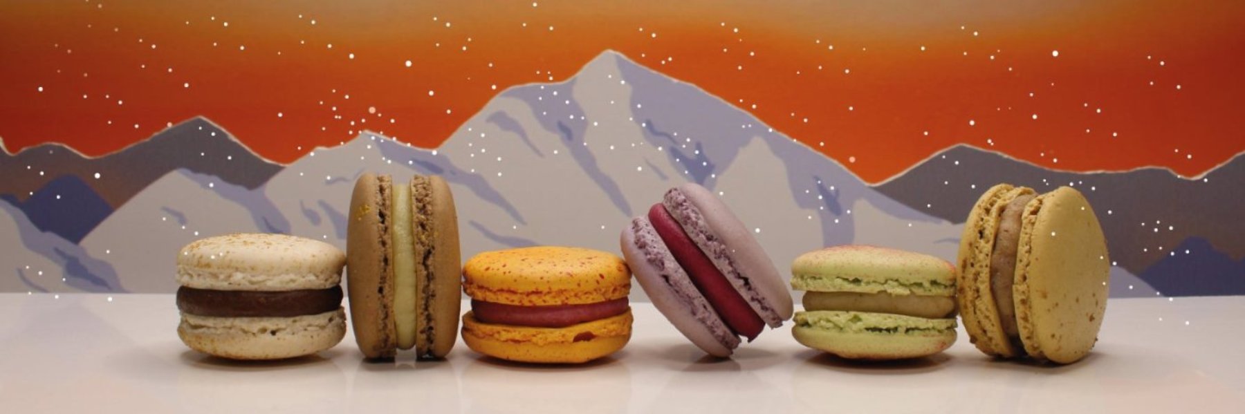 A snowy Swiss Alps scene showing our six festive macaron flavours.